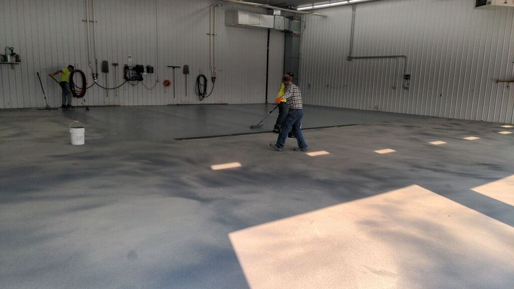 Three men epoxy coating a large floor